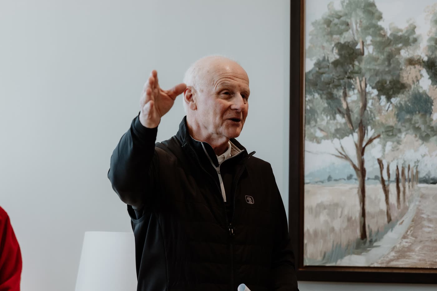 David McKinley telling a story with a raised hand in the church parlor