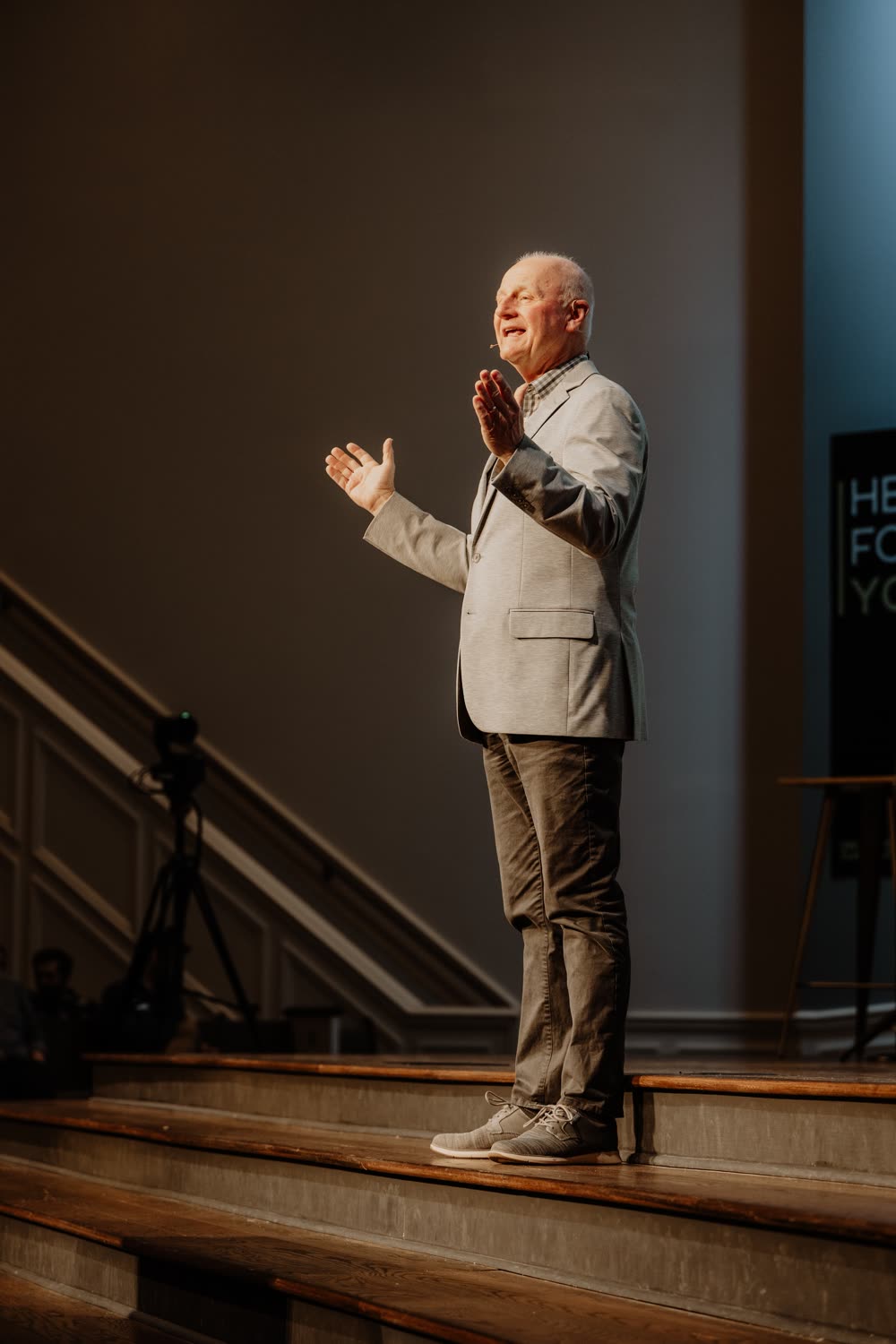 David McKinley standing on the Warren platform, applauding in worship